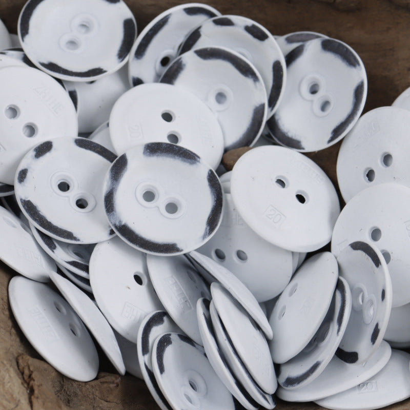 Mixed round two-hole metal buttons in white with dark speckle borders