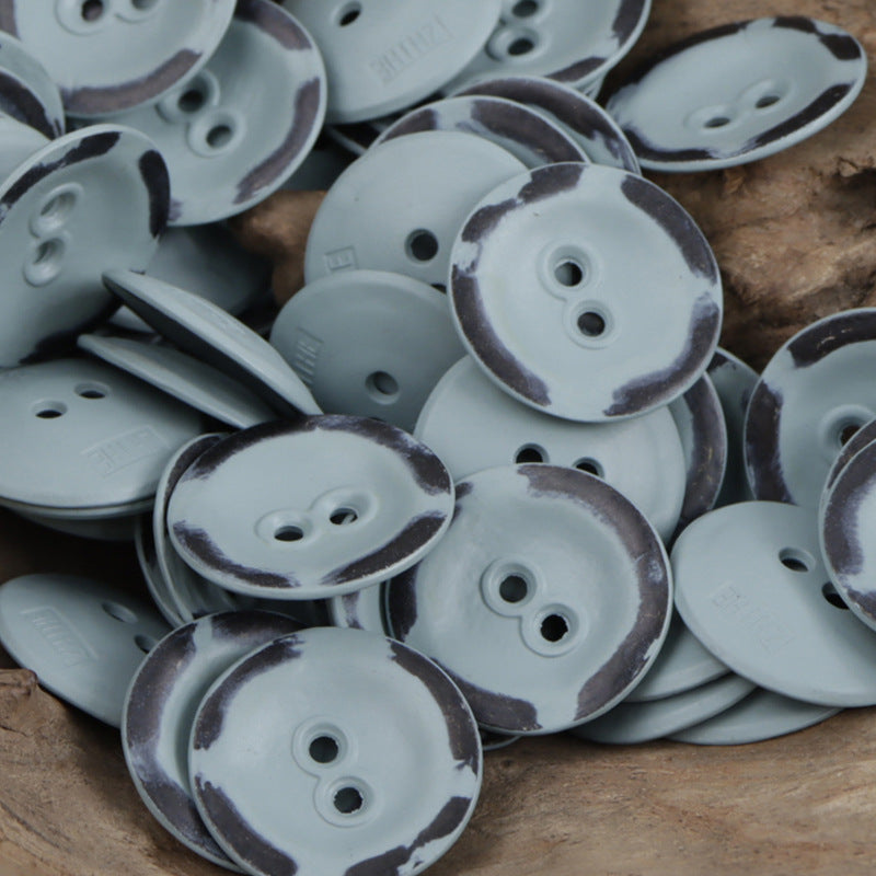 Two-hole metal buttons in light blue with dark speckle rims, assorted pile