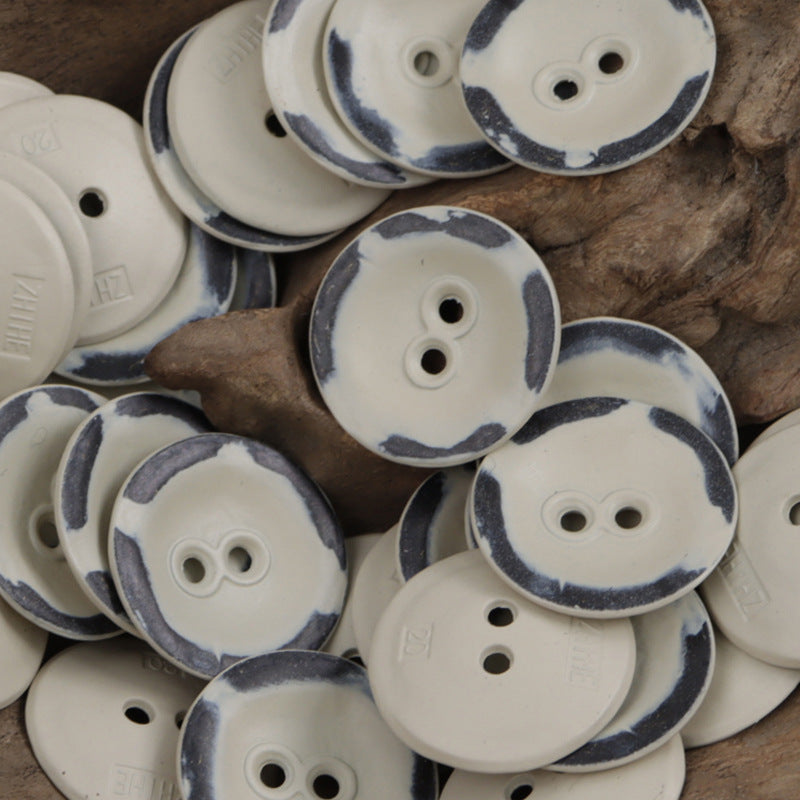 White and pale buttons with dark speckle edges, two-hole design, mixed pile