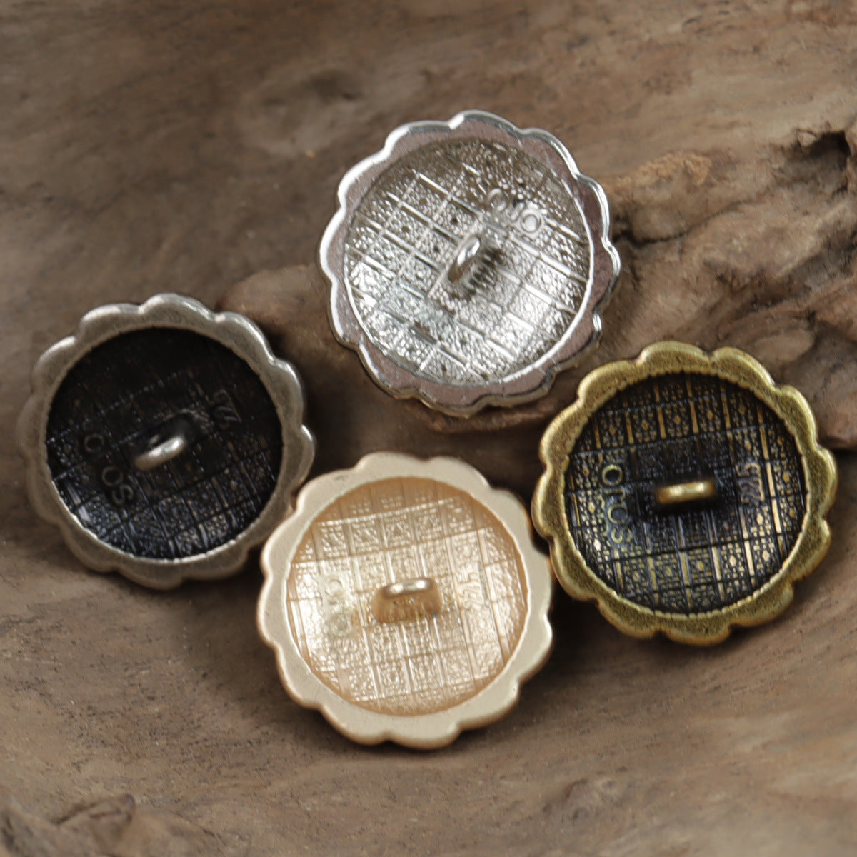 Back view of decorative coat metal buttons with embossed details, assorted finishes