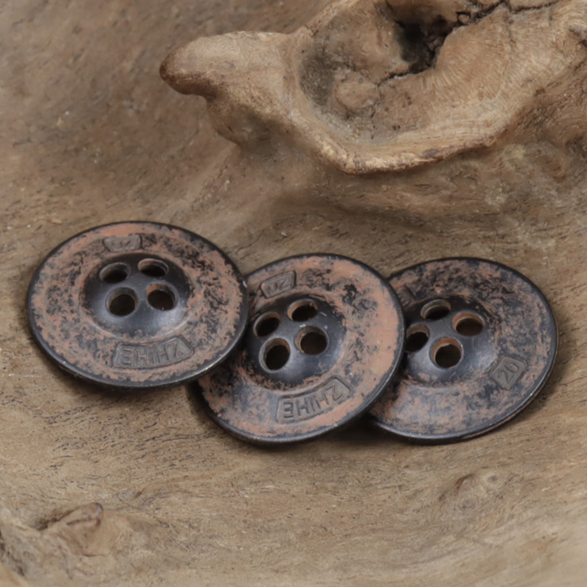 3 rostfarbene Metallknöpfe, jeweils mit 4 Löchern, geprägte Oberfläche