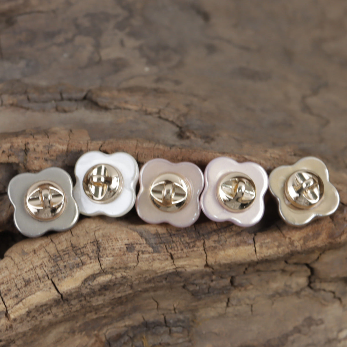 Row of cloud resin buttons: gray, white, pink, and gold with metal shanks