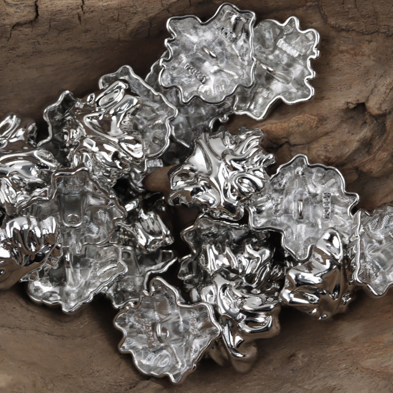 3D leaf-shaped metal buttons with shank, silver finish, close-up pile