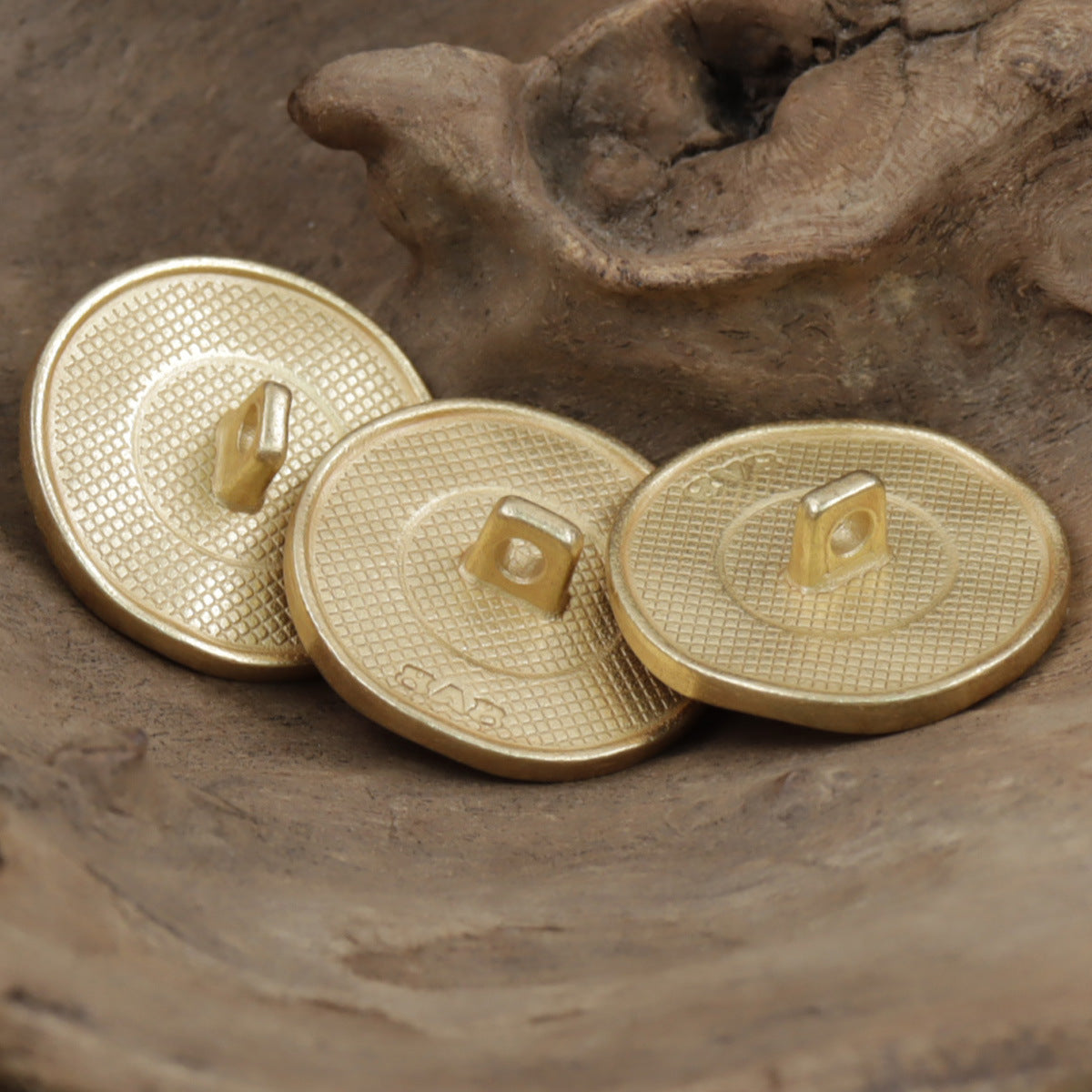 Misty gold coat buttons with black pearl center, three buttons shown