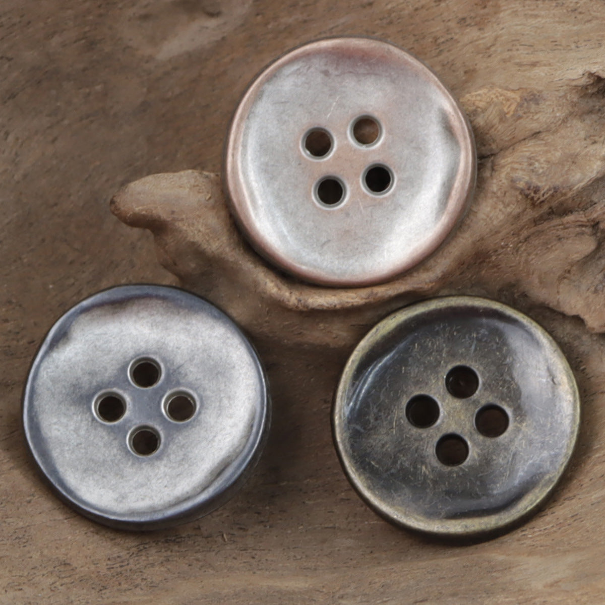 Retro 4-hole metal buttons, antique silver finish on wood surface