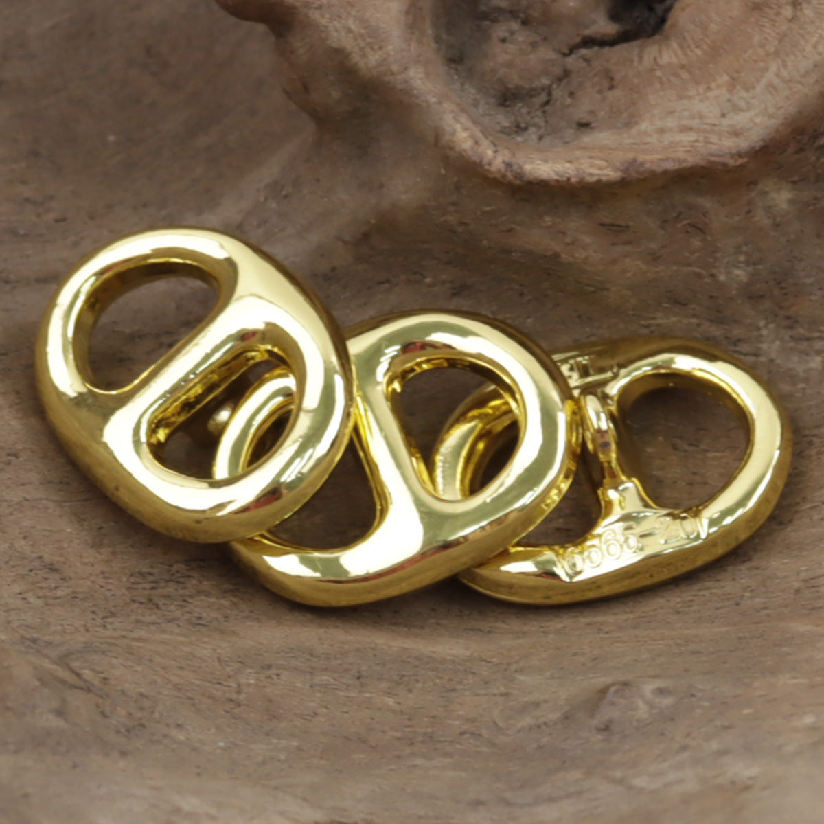 Close-up gold pig nose-shaped metal button with shank underside