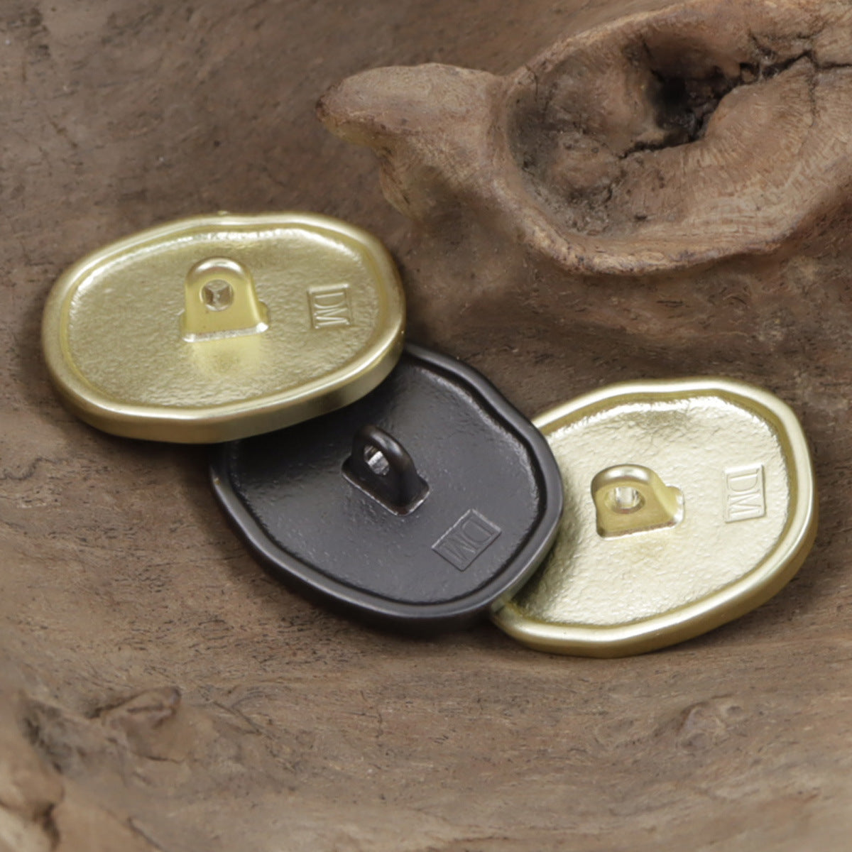 Gold metal button pair with shank backs visible, oval painted girl designs