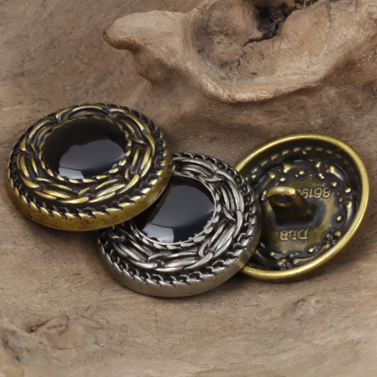Bronze and black-silver metal buttons with braided rim and dark center cabochons