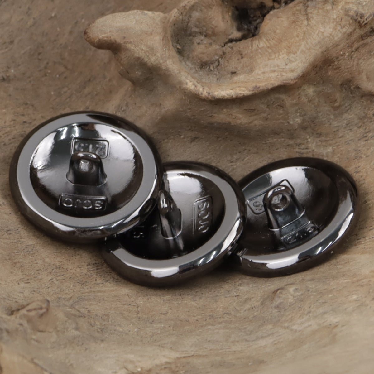 Camellia shank buttons, shiny black backs with stamped details and pin loops