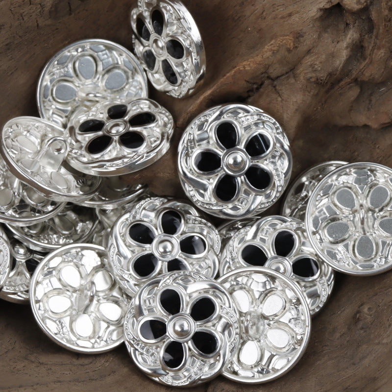 Daisy-shaped metal buttons with dark center inlays, silver tone, engraved petal pattern