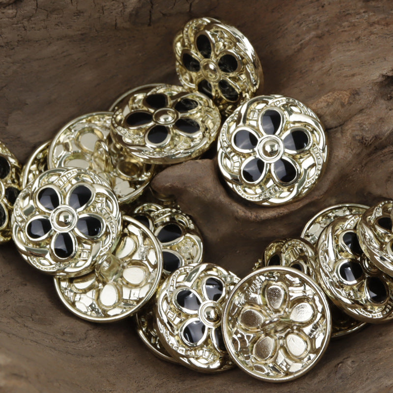 Daisy-shaped metal buttons in gold tone with dark centers, engraved petal design