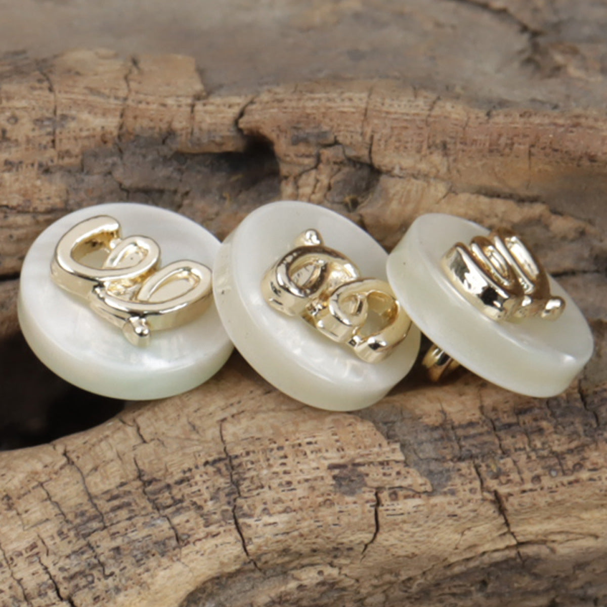 Beige runde Kunstharzknöpfe mit Metallschlaufe, Vorderseite mit Zierdetail