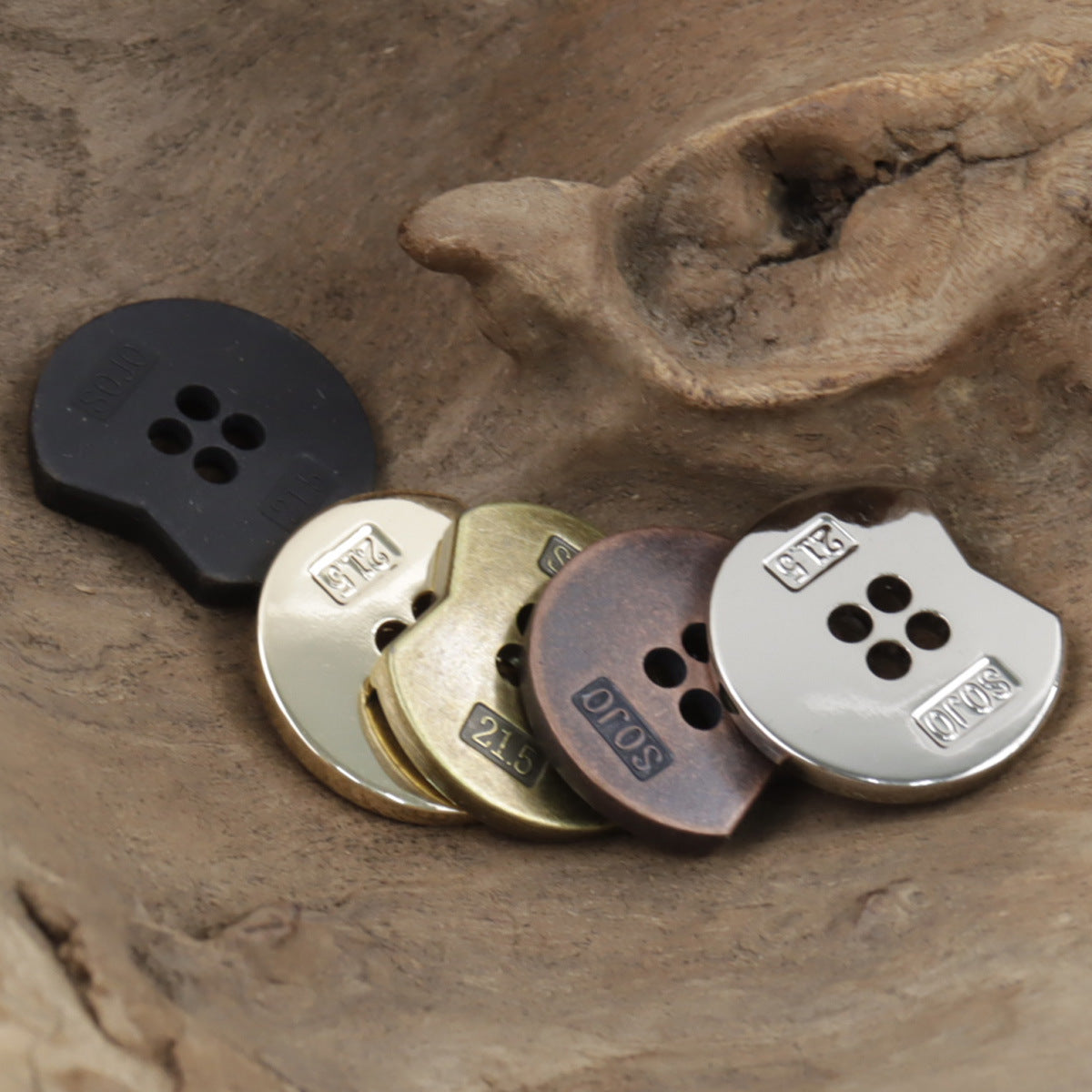 Irregular notched 4-hole metal buttons, stacked view with dark and bronze finishes