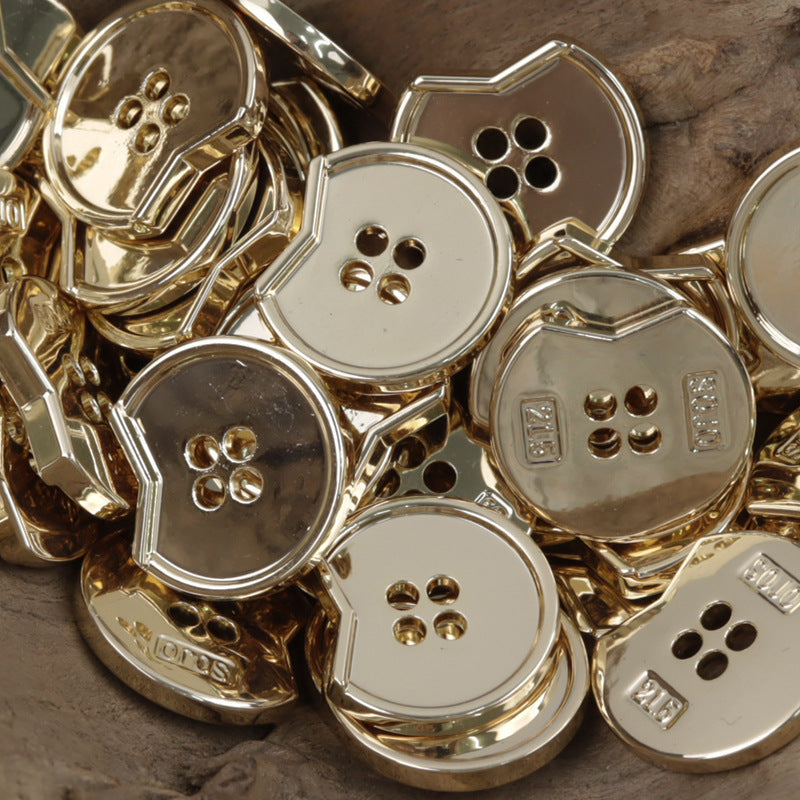 Minimalist irregular notched 4-hole metal buttons, close-up with gold and silver tones