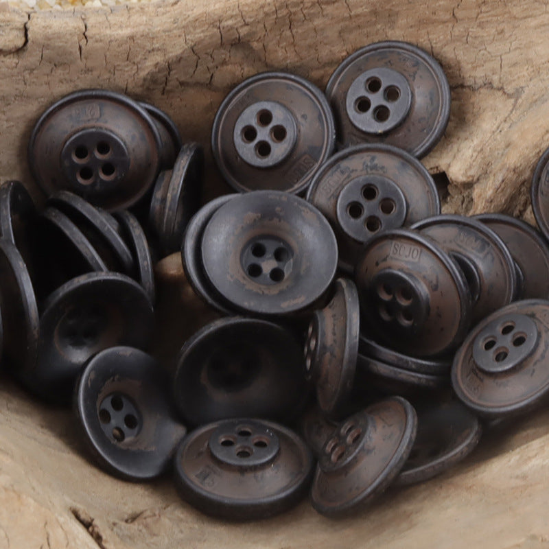 Vintage metal buttons with dark gray and rust-toned patina, four-hole fronts
