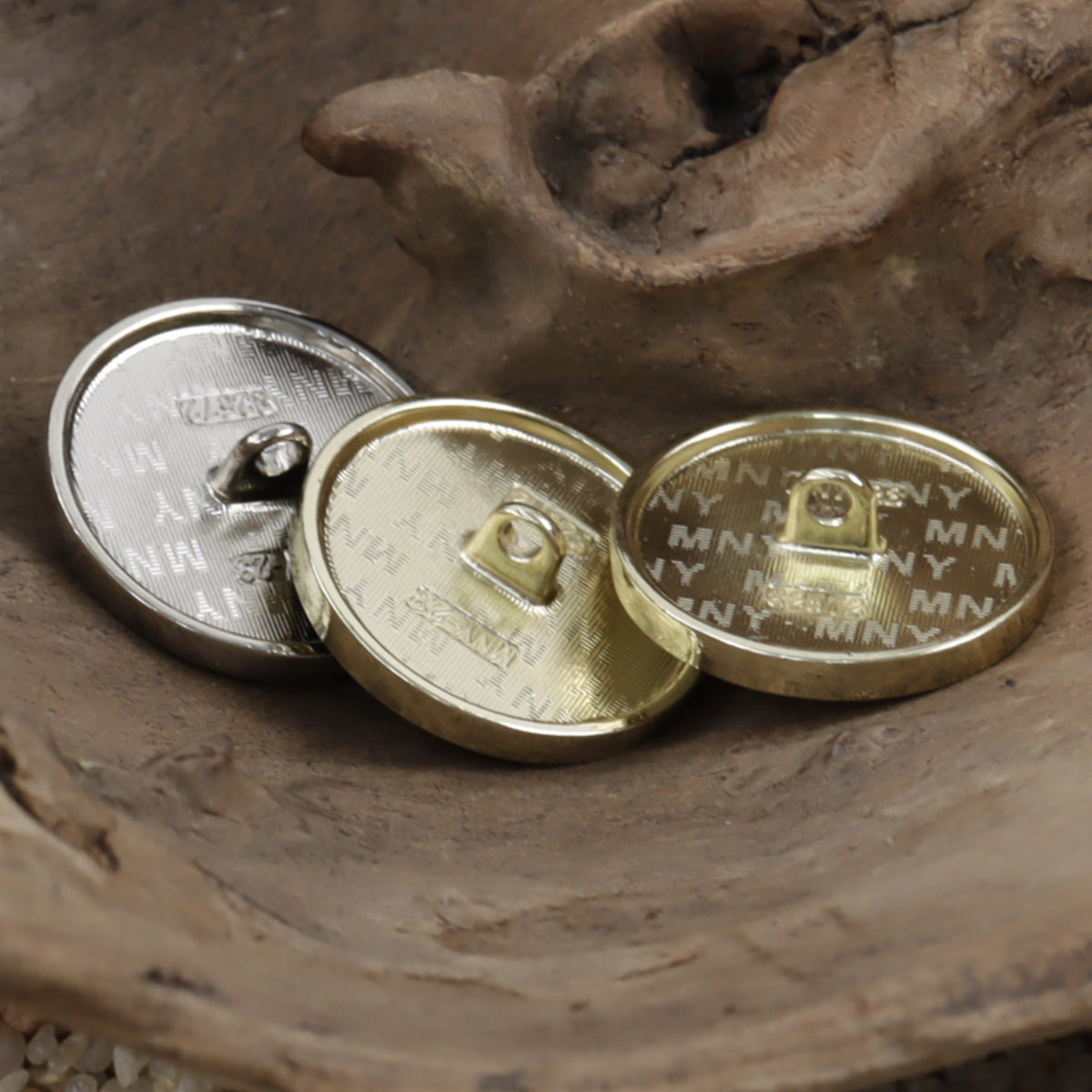 Metal button backs with shank loops and engraved initials, gold and silver tones