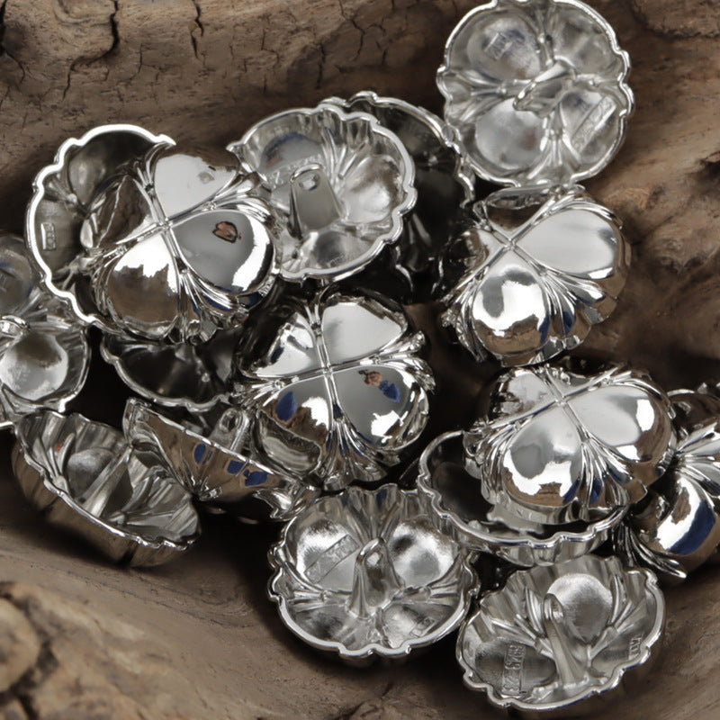Four-leaf clover metal shank buttons in silver finish, stacked close-up