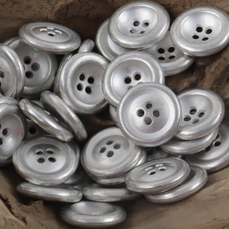 Vintage silver 4-hole double-sided metal buttons, multiple buttons close-up