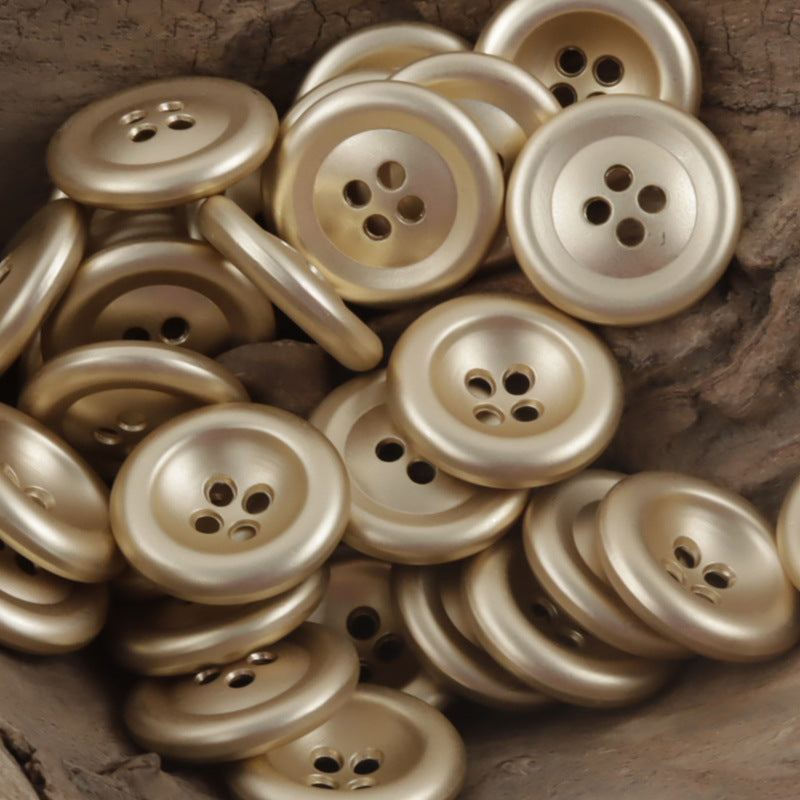 Vintage gold-toned 4-hole double-sided metal buttons, multiple buttons close-up
