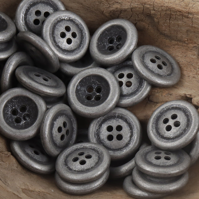 Vintage aged silver 4-hole double-sided metal buttons, textured patina close-up