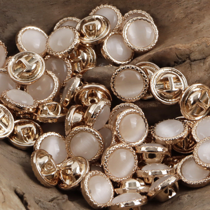 Assorted pearlescent metal shirt buttons with white front stones and gold/silver-tone frames