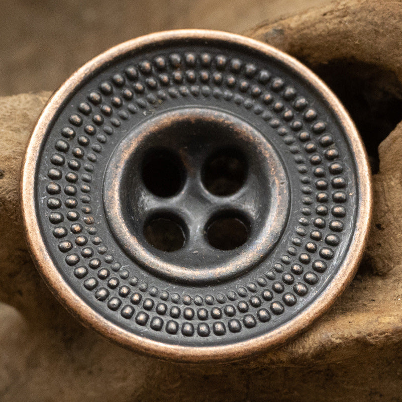Antique cap-shaped metal button in dark tin with embossed dotted outer ring