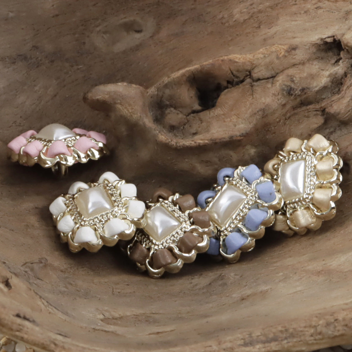 Square metal pearl buttons on leather cord with pink, white, and blue squares