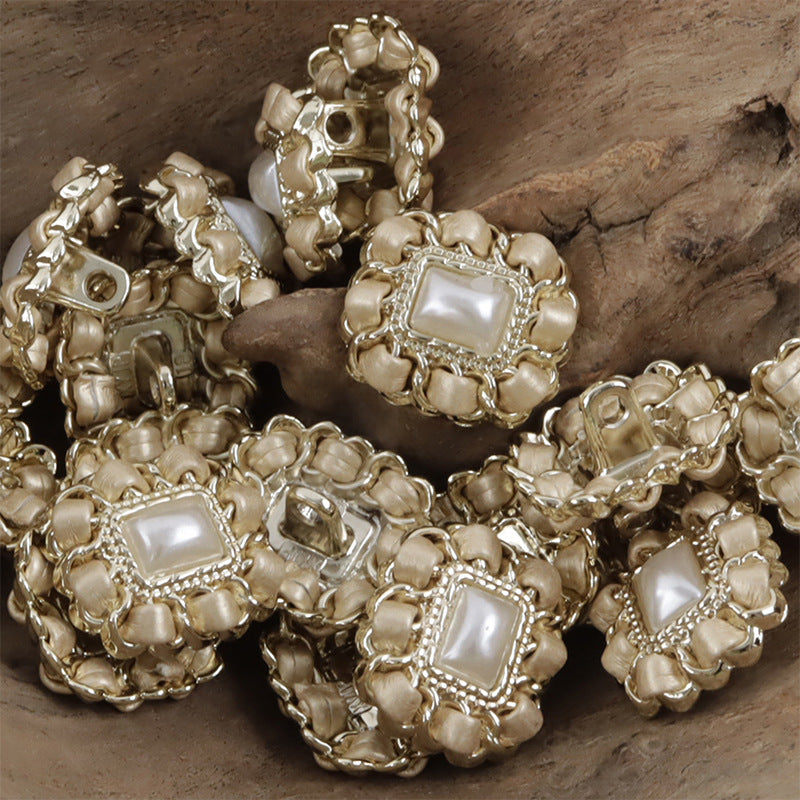 Beige-gold square metal pearl buttons with leather cord weaving, stacked close-up