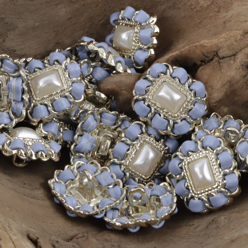 Blue square metal pearl buttons with leather cord weaving, clustered close-up