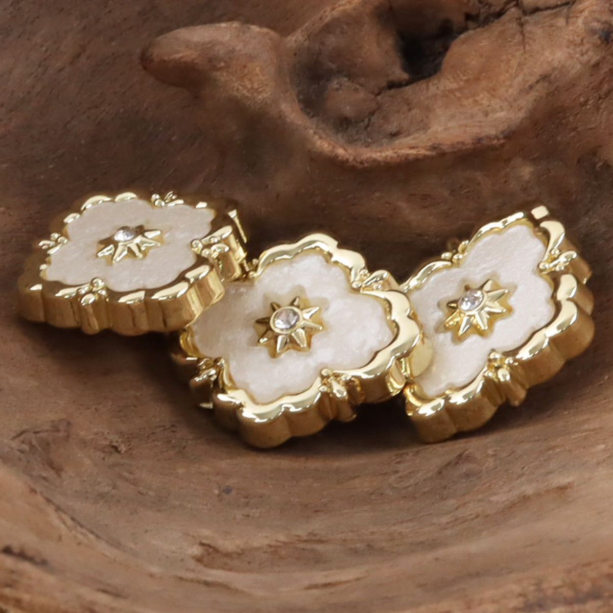 Set of golden buttons with white scalloped inlay and star-shaped diamond accents