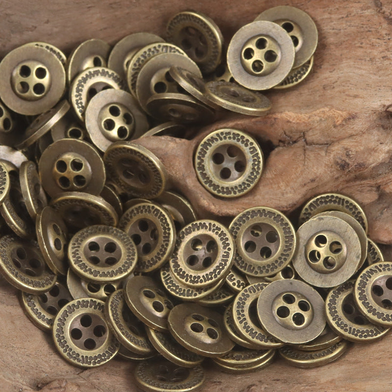 Bronze metal flat buttons pile with ornate border and dotted rim details