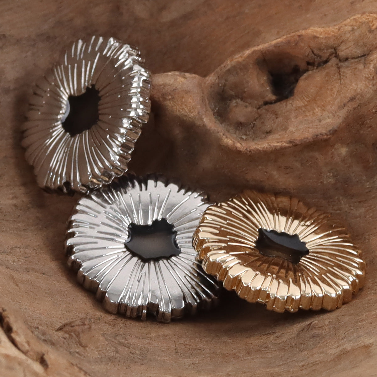Snowflake metal buttons with black center, silver and gold finishes (close-up)