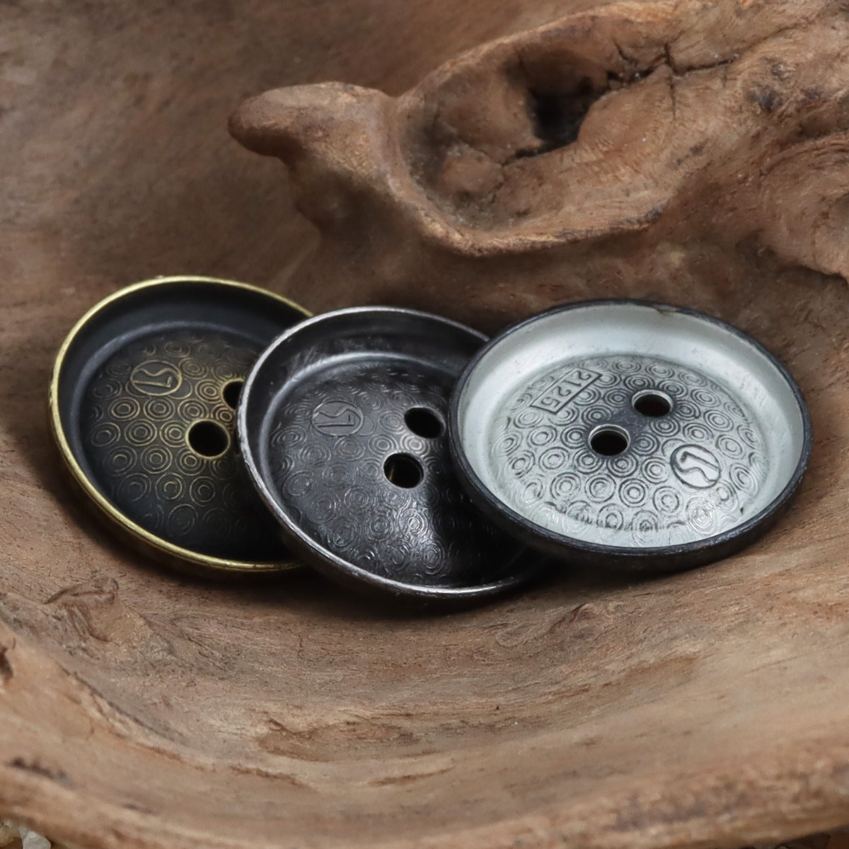 Set of antique-tone metal buttons on round bases, distressed engravings, two-hole style