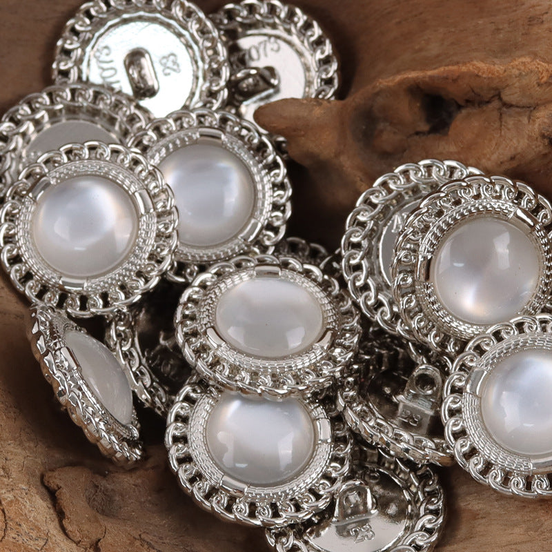 Silver-edged buttons with white resin gem centers and textured scalloped frames
