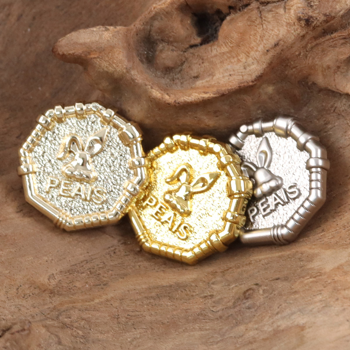 Metal buttons in gold and silver tones, “PEAS” text with rabbit sheriff crest