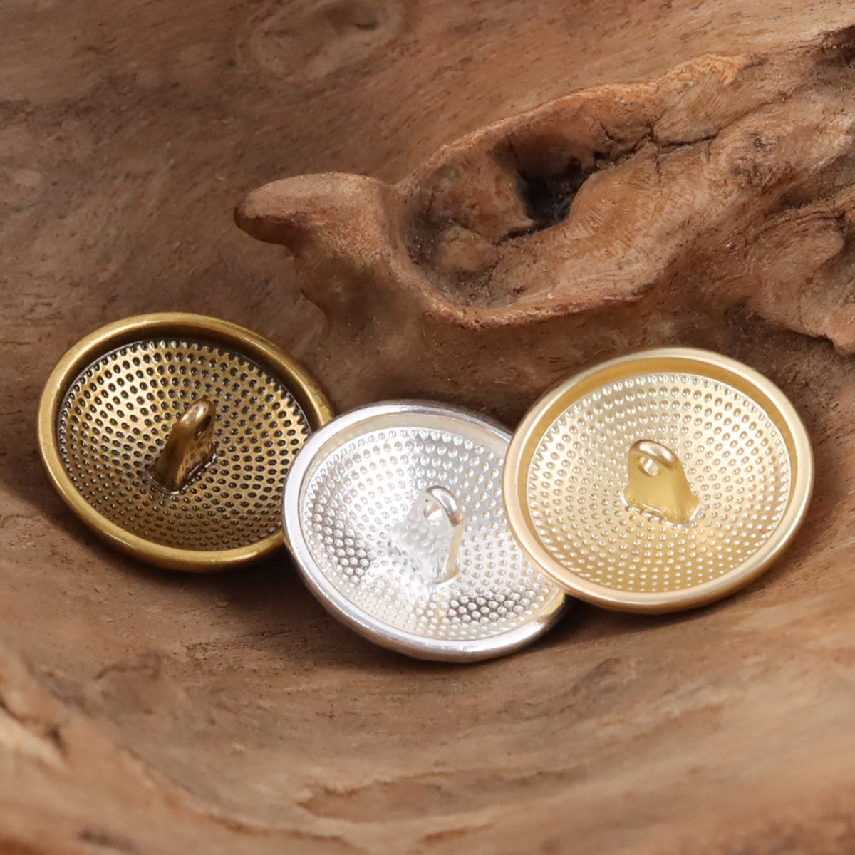 Metal shank buttons in gold, silver, and dark bronze tones, with visible loop shanks