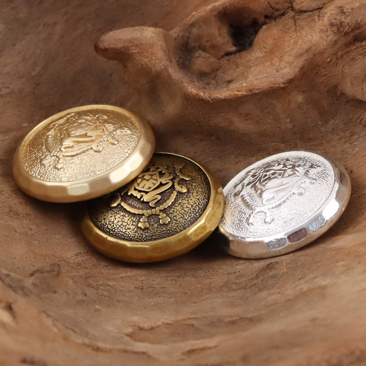 Metal shank buttons: gold, dark bronze, and silver round fronts with ornate crest pattern