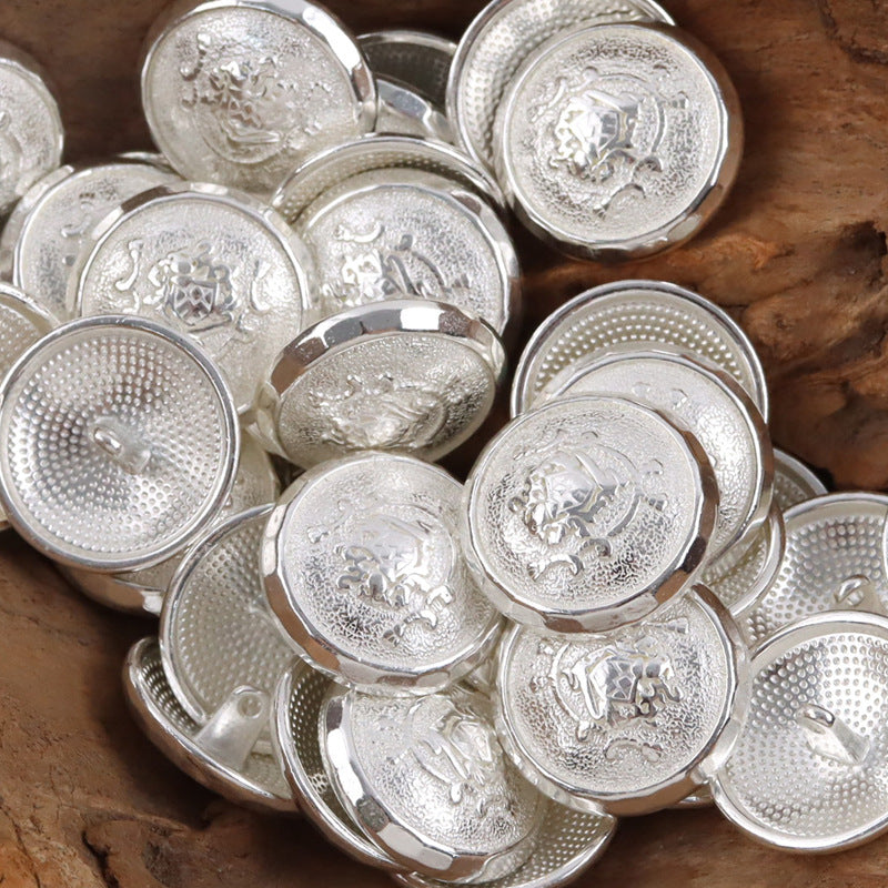 Silver-tone metal shank buttons, round fronts with ornate crest embossing and loop backs