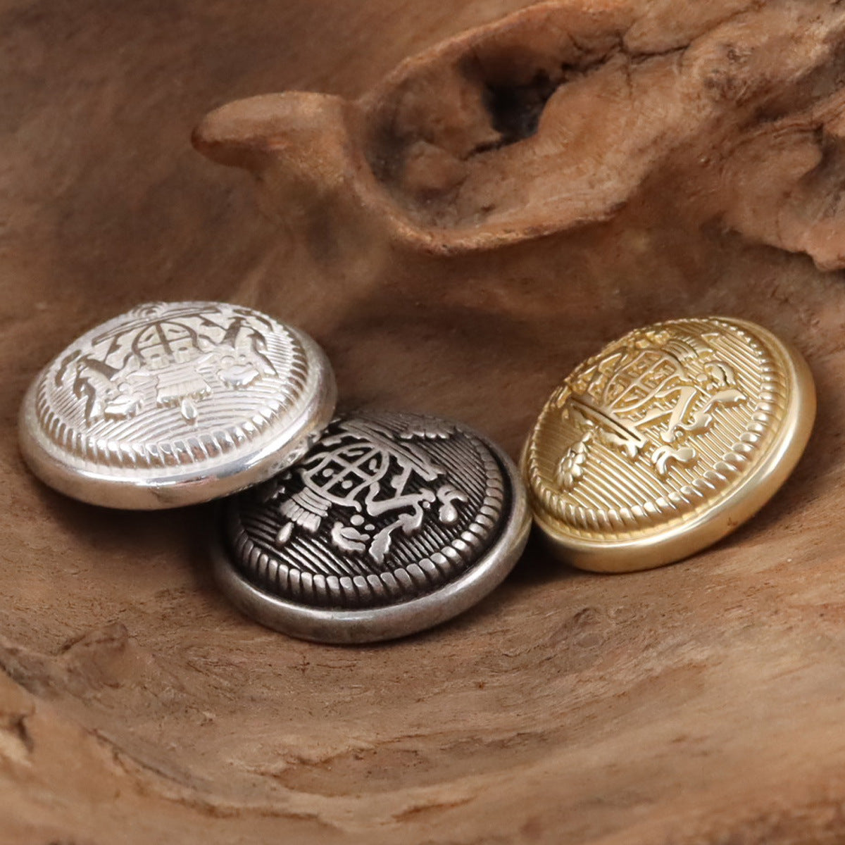 Round crown-shield buttons in silver, black-silver, and gold with ridged borders