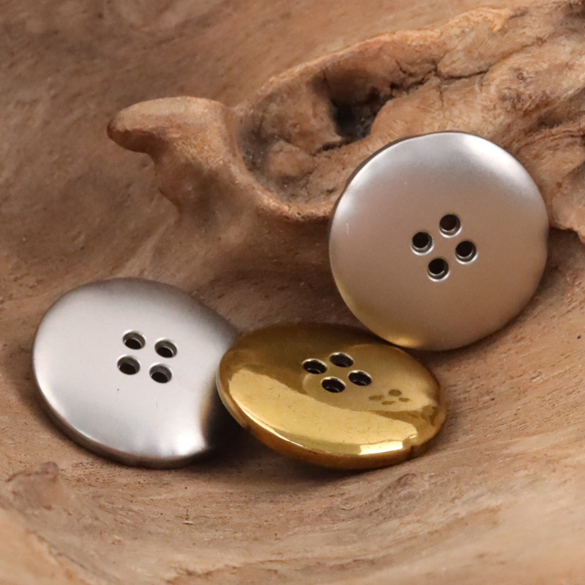 Irregular metal buttons in silver and gold, round 4-hole caps for coats.