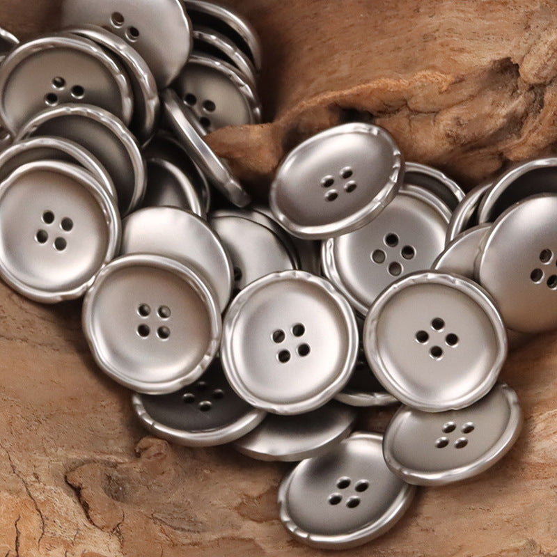 Pack of irregular round metal buttons in silver, each with 4-hole shank.
