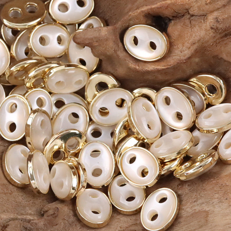 Pig nose resin buttons, white faces with gold-tone metal rims, oval 2-hole style