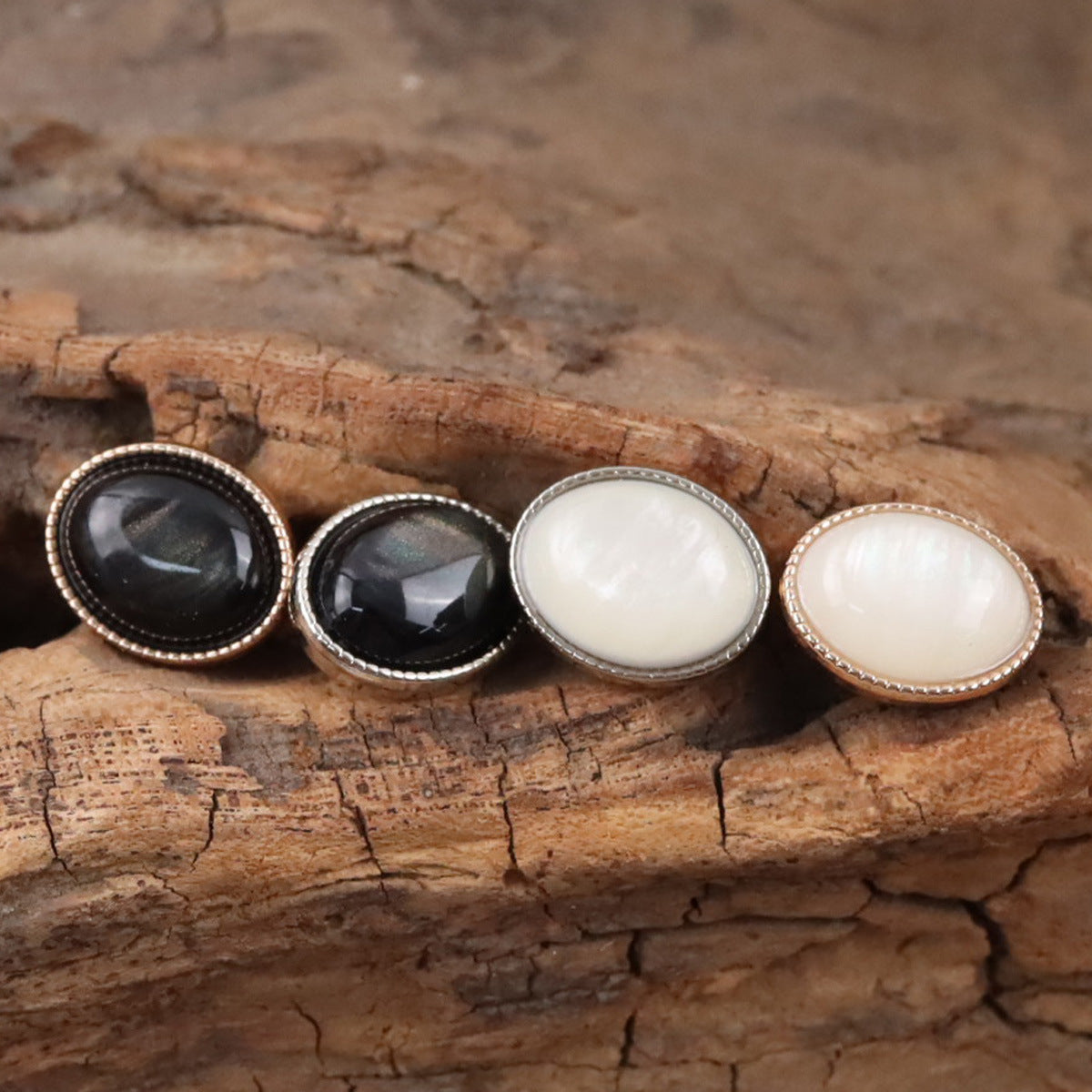 Oval resin shank buttons: black and white fronts with silver and gold-toned rims.