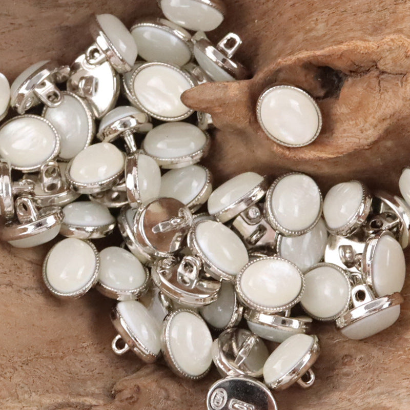 Oval resin pebble shank buttons, white fronts with silver rims.