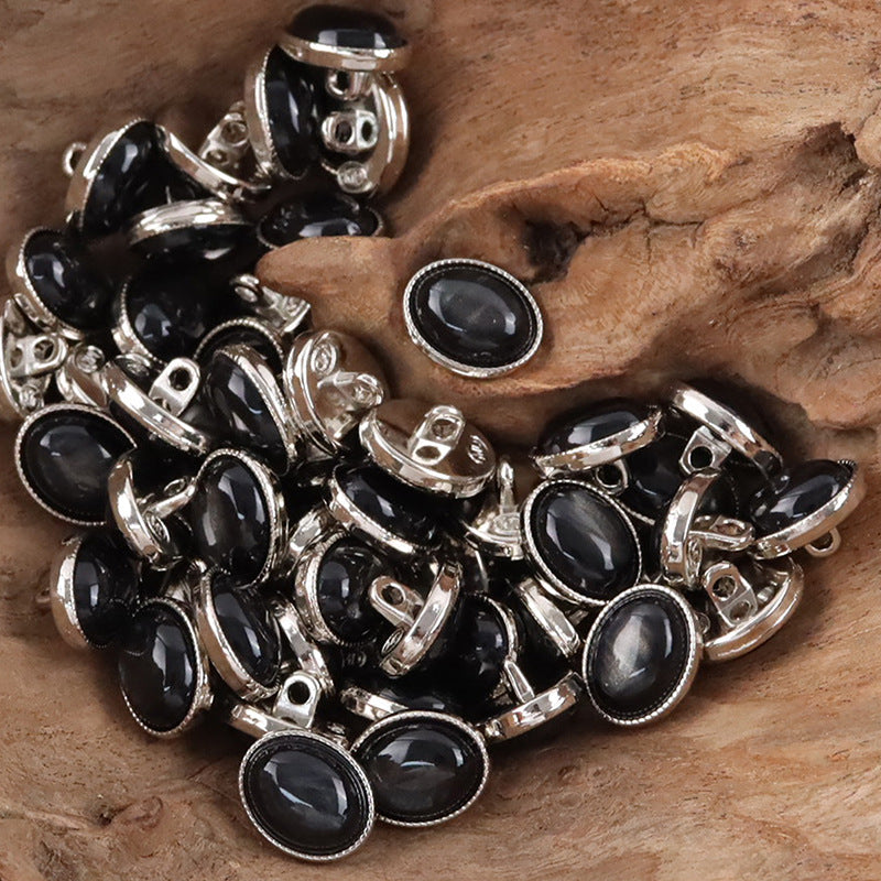 Oval resin pebble shank buttons, dark fronts with silver-toned rims.