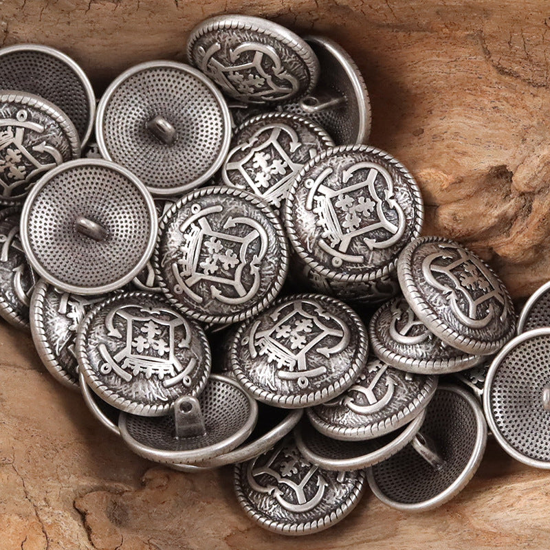 Silver-tone anchor hook metal buttons, close view of crest emblem and textured border