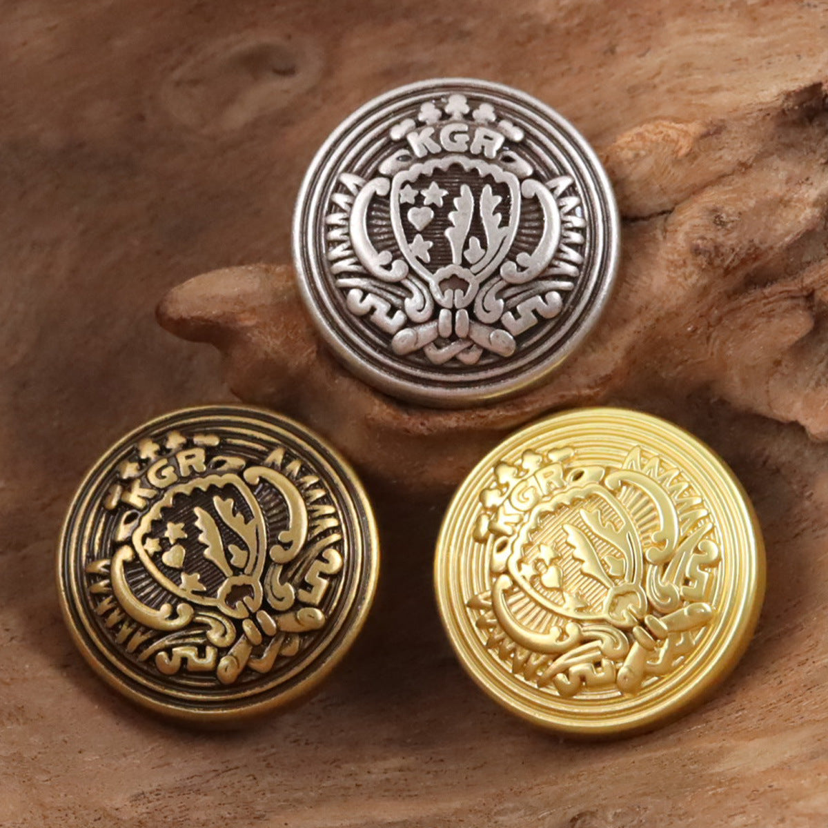 Round metal shield buttons in silver, bronze, and gold tones with engraved crest details