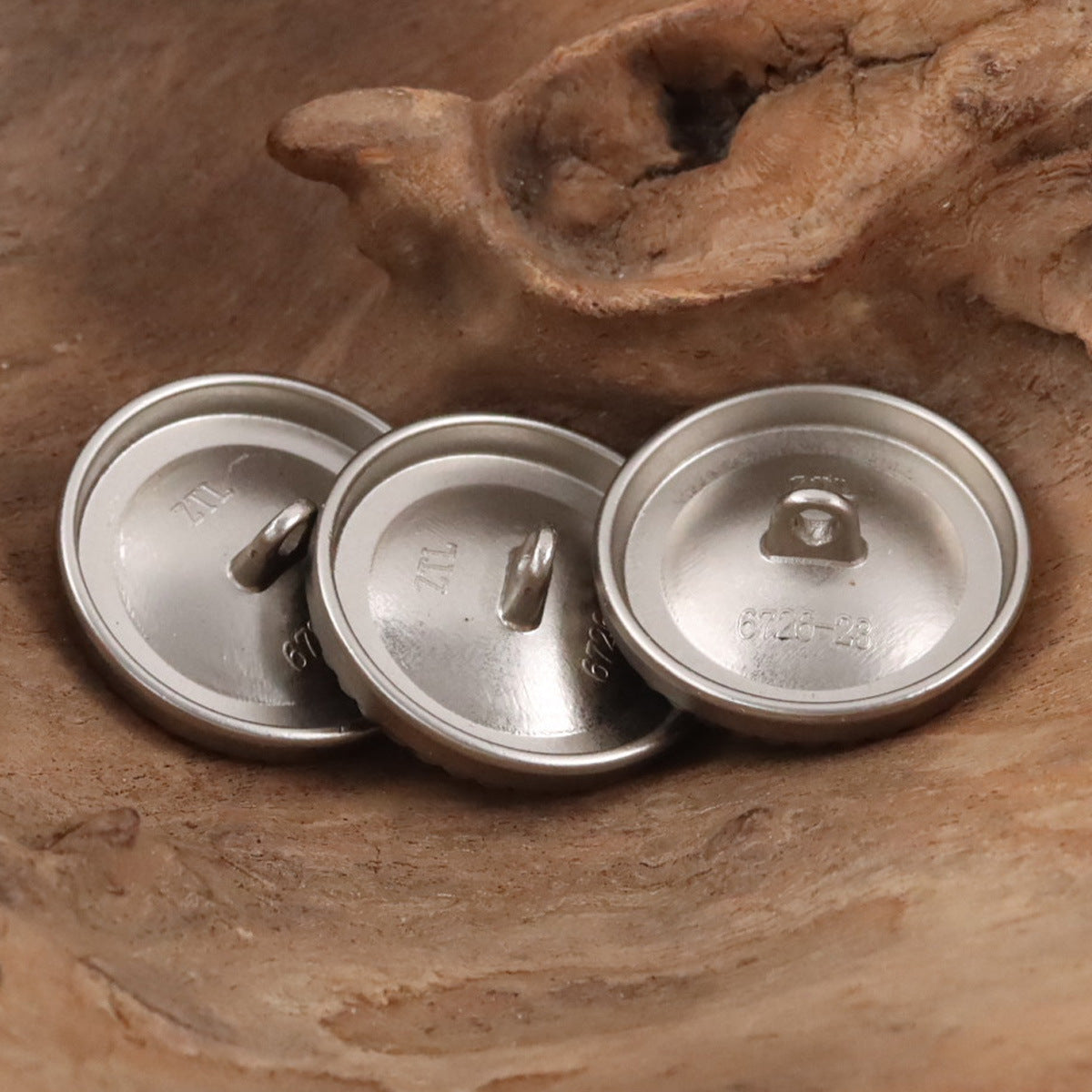 Back view of silver metal coat buttons with threaded shank, 3 pieces
