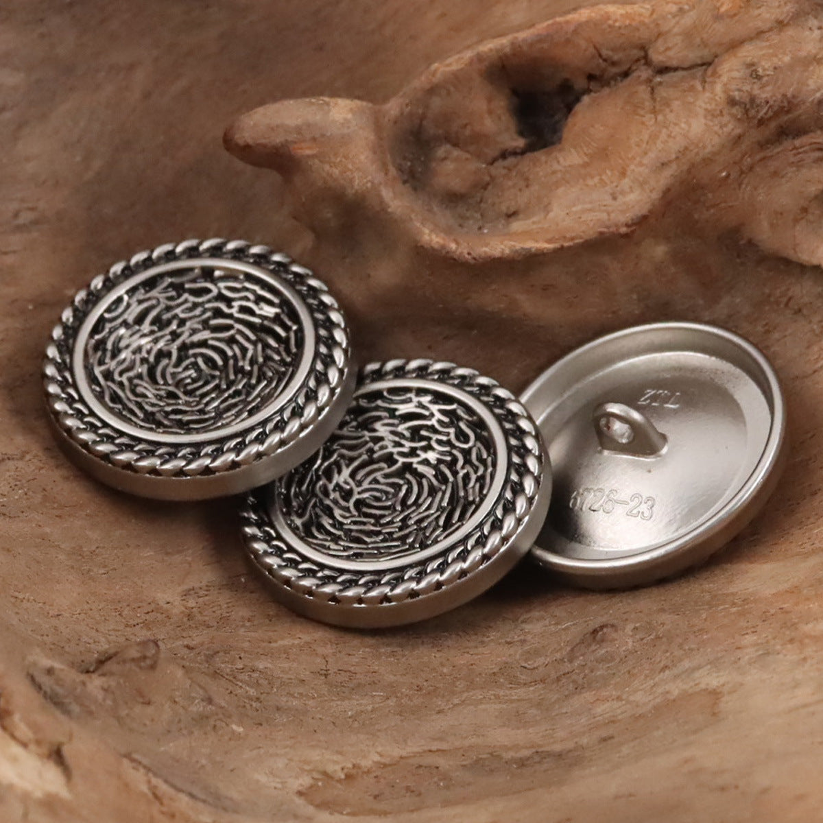 Set of round silver metal buttons with engraved swirl pattern and rope rim