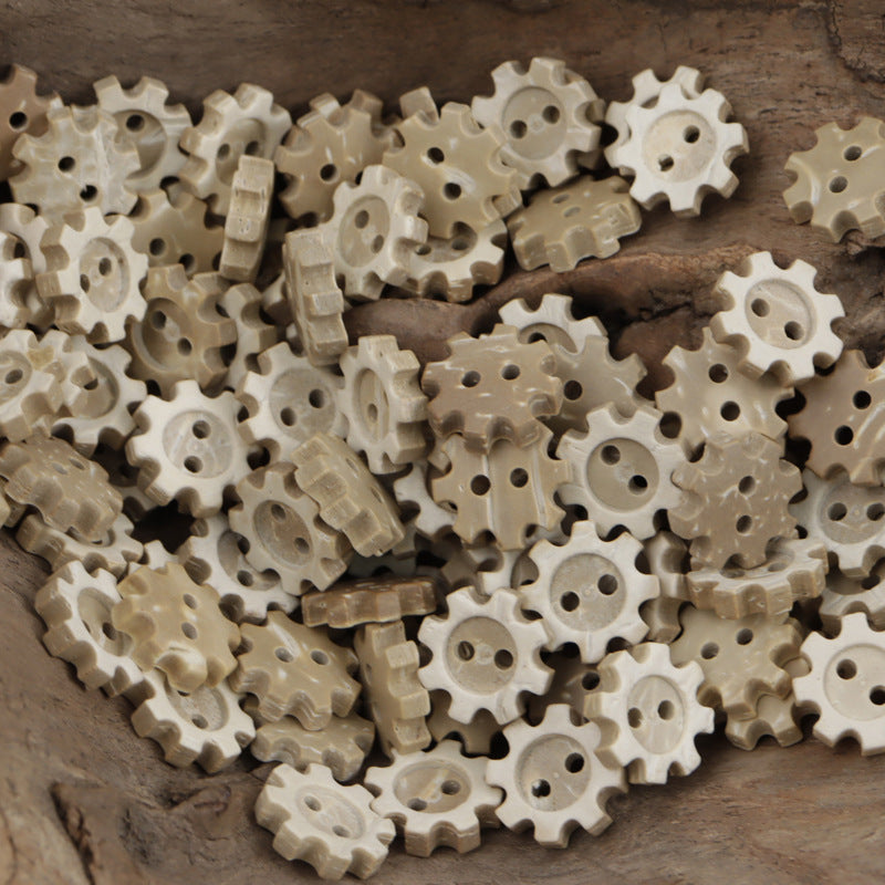 Two-hole coconut shell gear buttons, light tan, spoked edges on scattered pieces